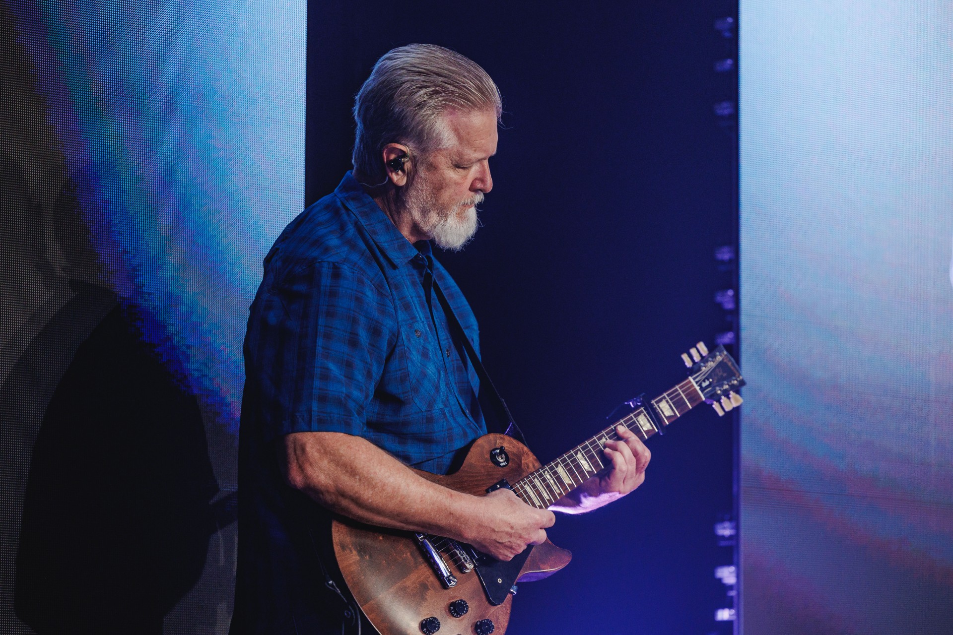 Photo of Brian Smothers playing guitar on stage at his local church.