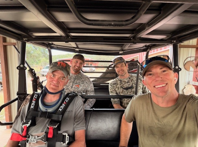 Photo of David Hutzler sitting in a golf cart with his family.