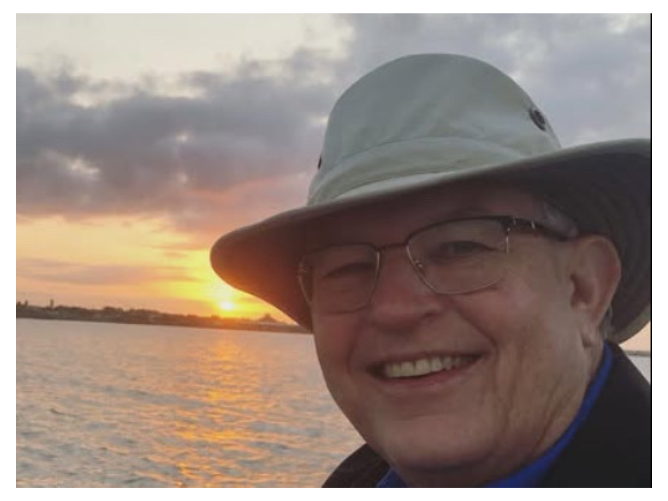 Photo of Thomas Mayes in front of sunset.