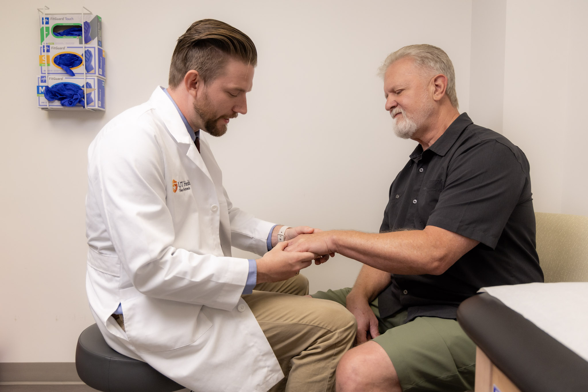 Grateful patient sitting with Dr. Jason Coffman for a check-up appointment