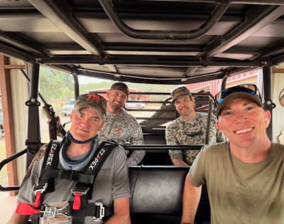 Photo of David Hutzler sitting in a golf cart with his family.