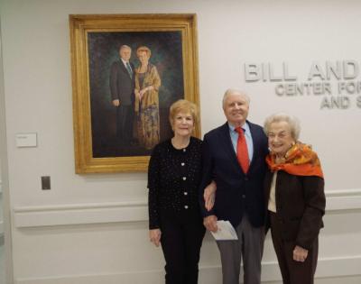 Rebecca Reed, Bill Reed and Ann Biggs are shown in front of a portrait of the Reeds at the Biggs Institute