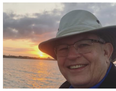Photo of Thomas Mayes in front of sunset.